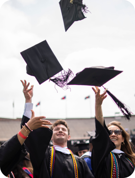 Graduates throwing caps in the air at ceremony